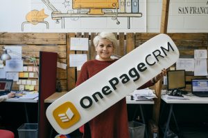 Kati holding a OnePageCRM sign